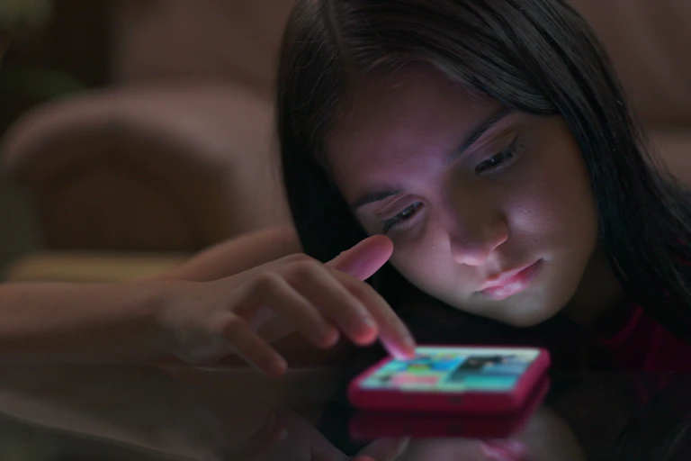 A girl scrolling on a mobile phone.