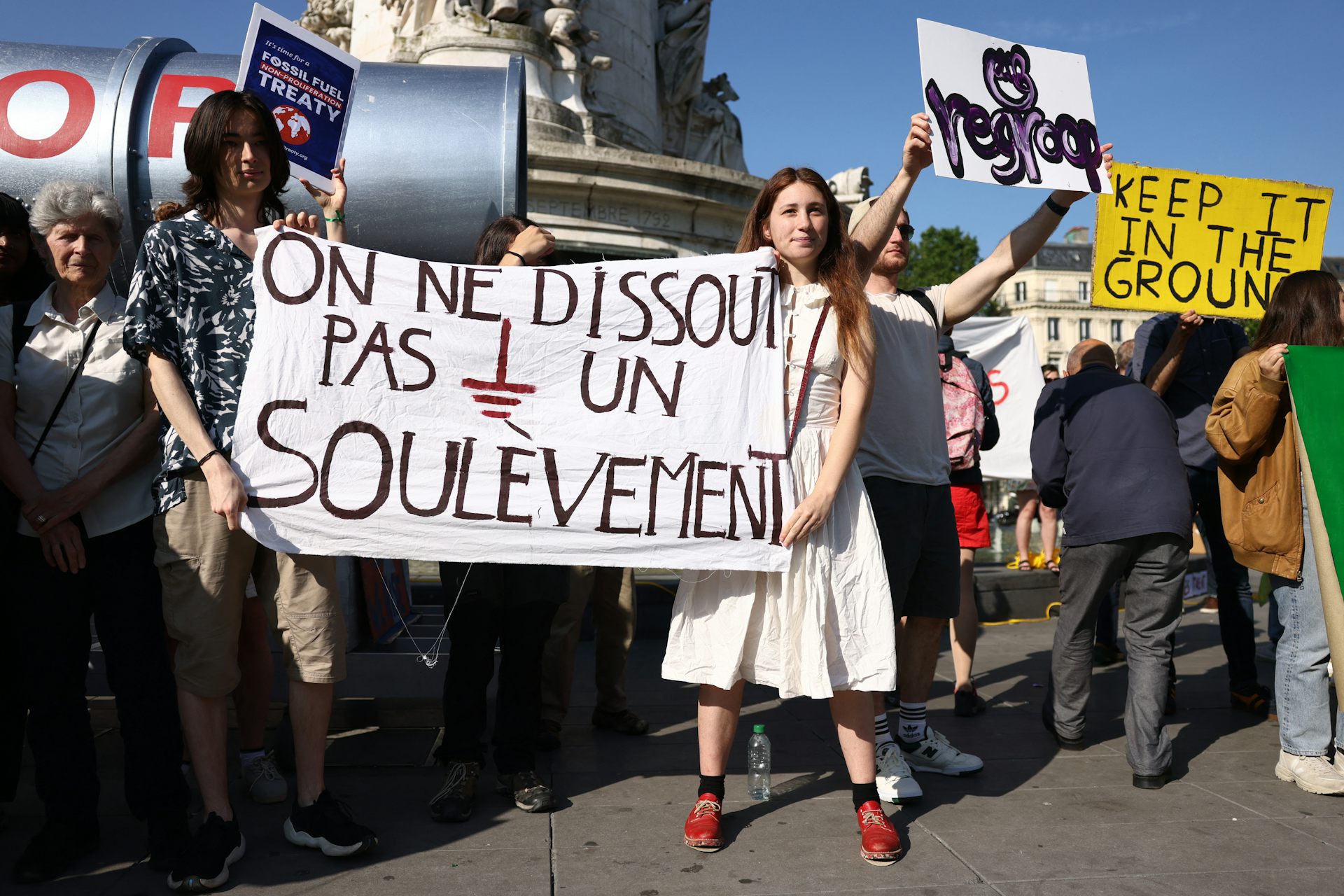 Des manifestants brandissent une banderole sur laquelle on peut lire « On ne démantèle pas un soulèvement » alors qu'ils manifestent contre les énergies fossiles et pour le climat, ainsi qu'en soutien au mouvement écologiste « Les Soulevements de la Terre », officiellement dissous par le gouvernement français, place de la République, en marge du sommet du Nouveau Pacte financier mondial, à Paris, le 23 juin 2023. (Photo de Thomas SAMSON / AFP)
