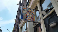 Imagen en la calle de la portada de un álbum en la que se ve un dibujo de la cara de un hombre con la boca abierta, gritando.