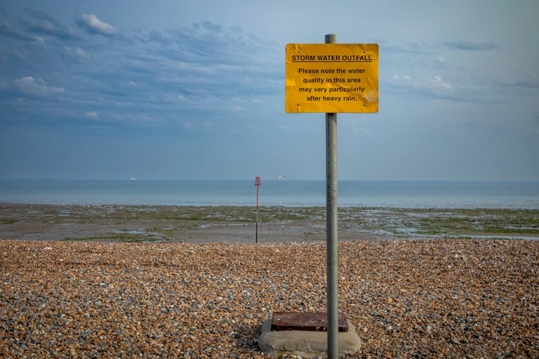 A sign warning of sewage outfall at West Wittering, West Sussex.