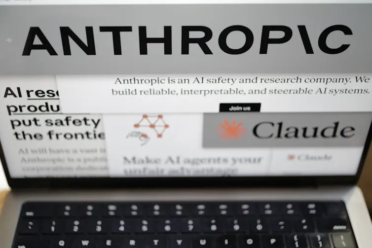 A laptop screen showing the Anthropic logo.