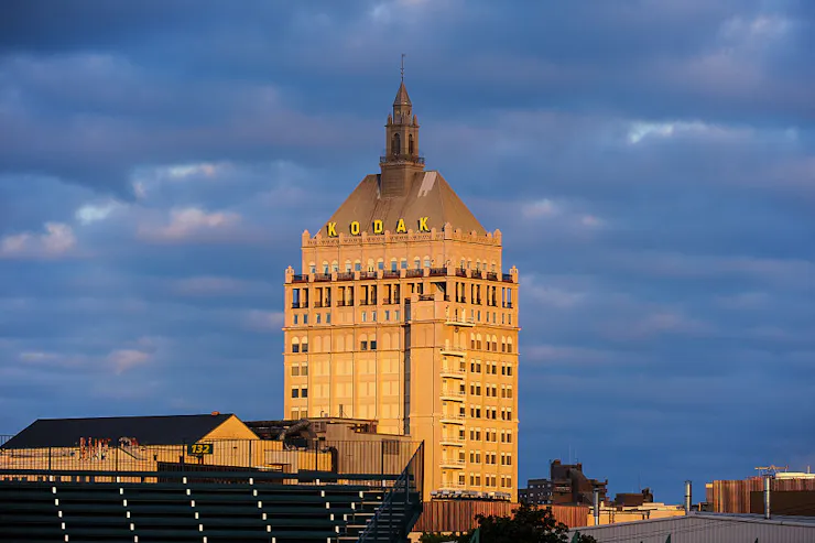 A 16-story skyscraper with a spire designed in the French Renaissance style standing against a backdrop of dramatic clouds.