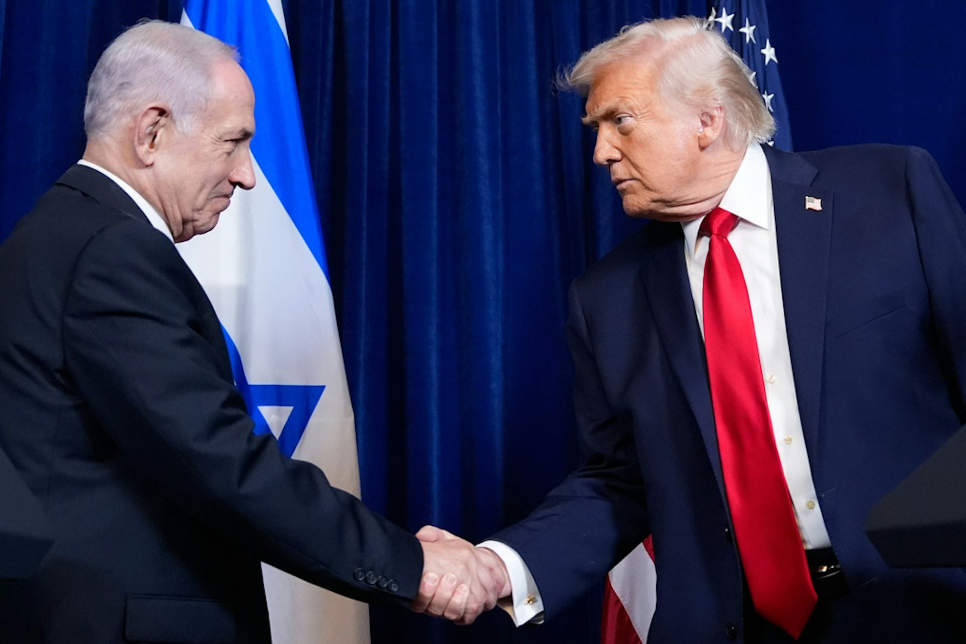 Two men in suits shakes hands.