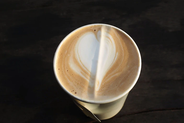 Un vaso de plástico lleno de café con leche visto desde arriba.