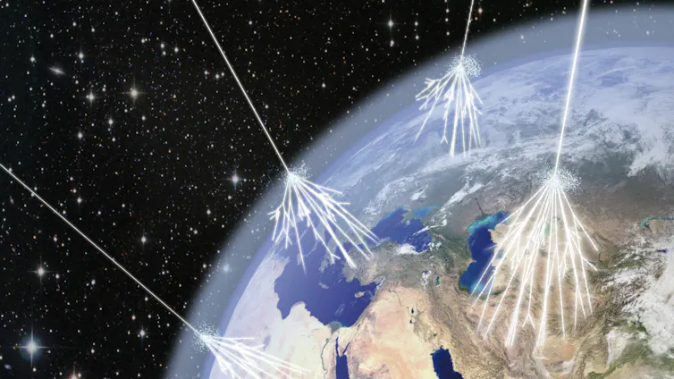 An illustration of cosmic rays striking Earth's atmosphere and creating showers of particles.