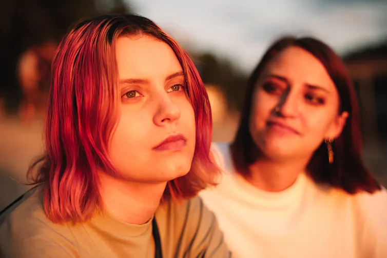 Person looking into the distance as their partner smiles at them