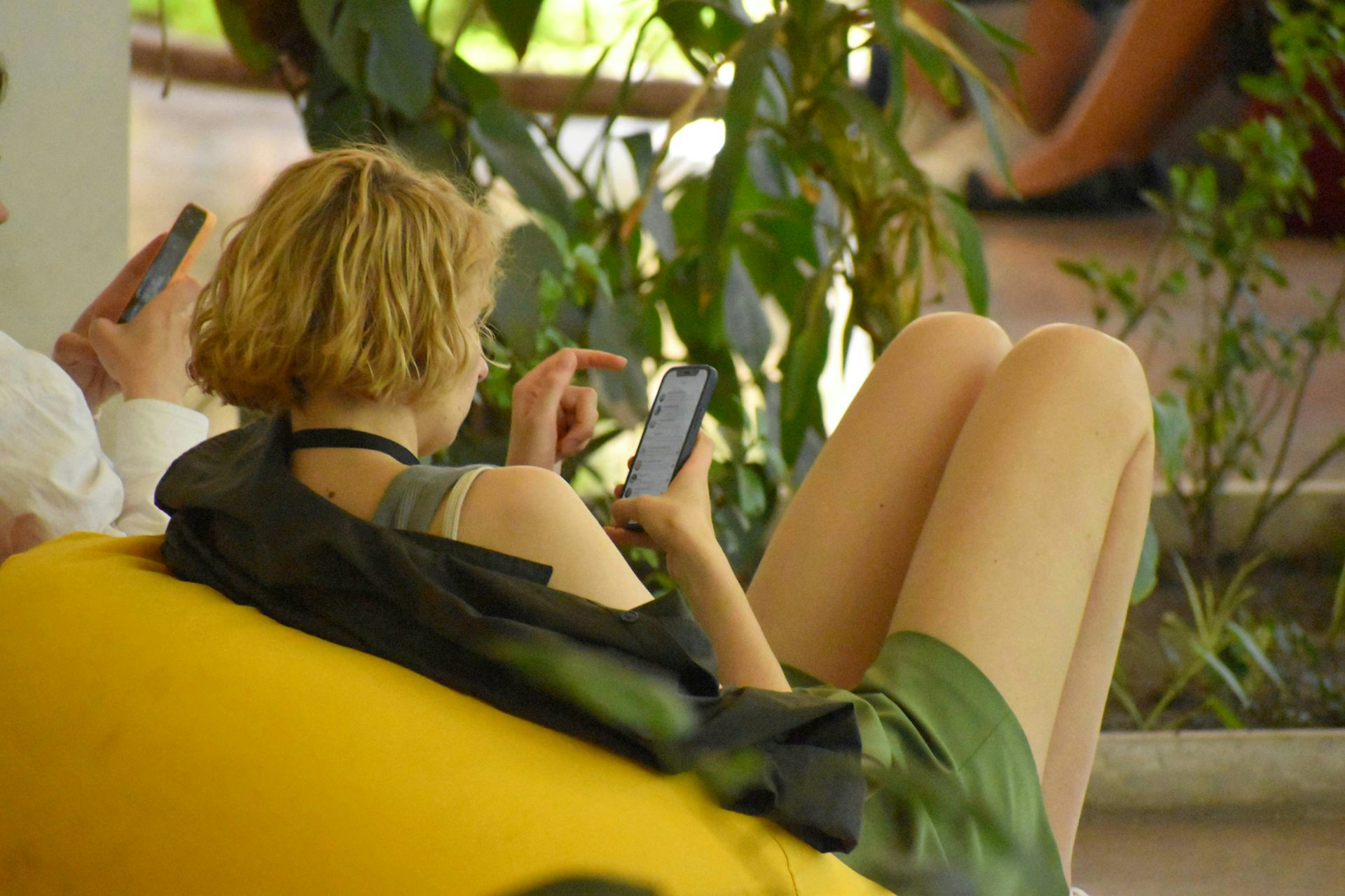 Una persona sentada en una silla hojeando su teléfono