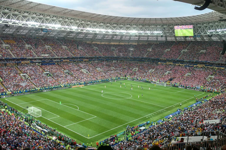 Vue panoramique du stade rempli de spectateurs regardant les joueurs sur le terrain.