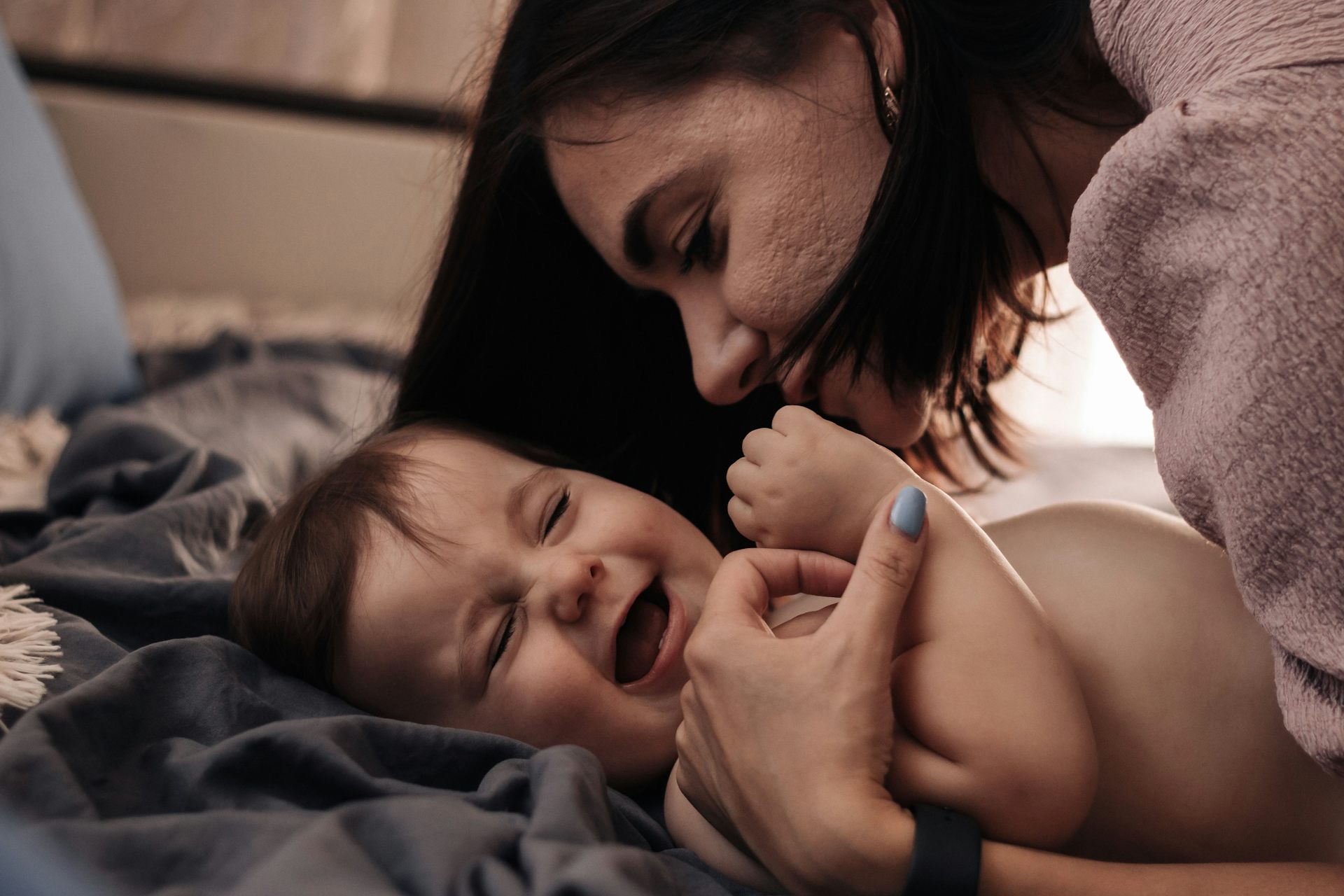 a woman leaning over a baby