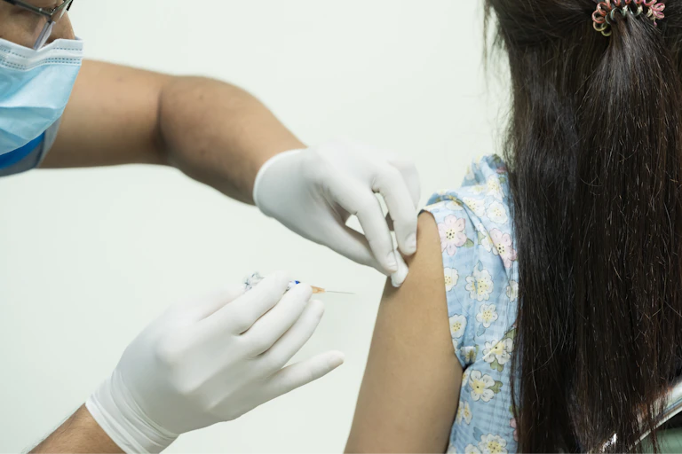 A girl receives a vaccine.