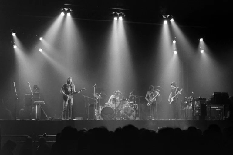 Una fotografía en blanco y negro de una banda de rock sobre un escenario.