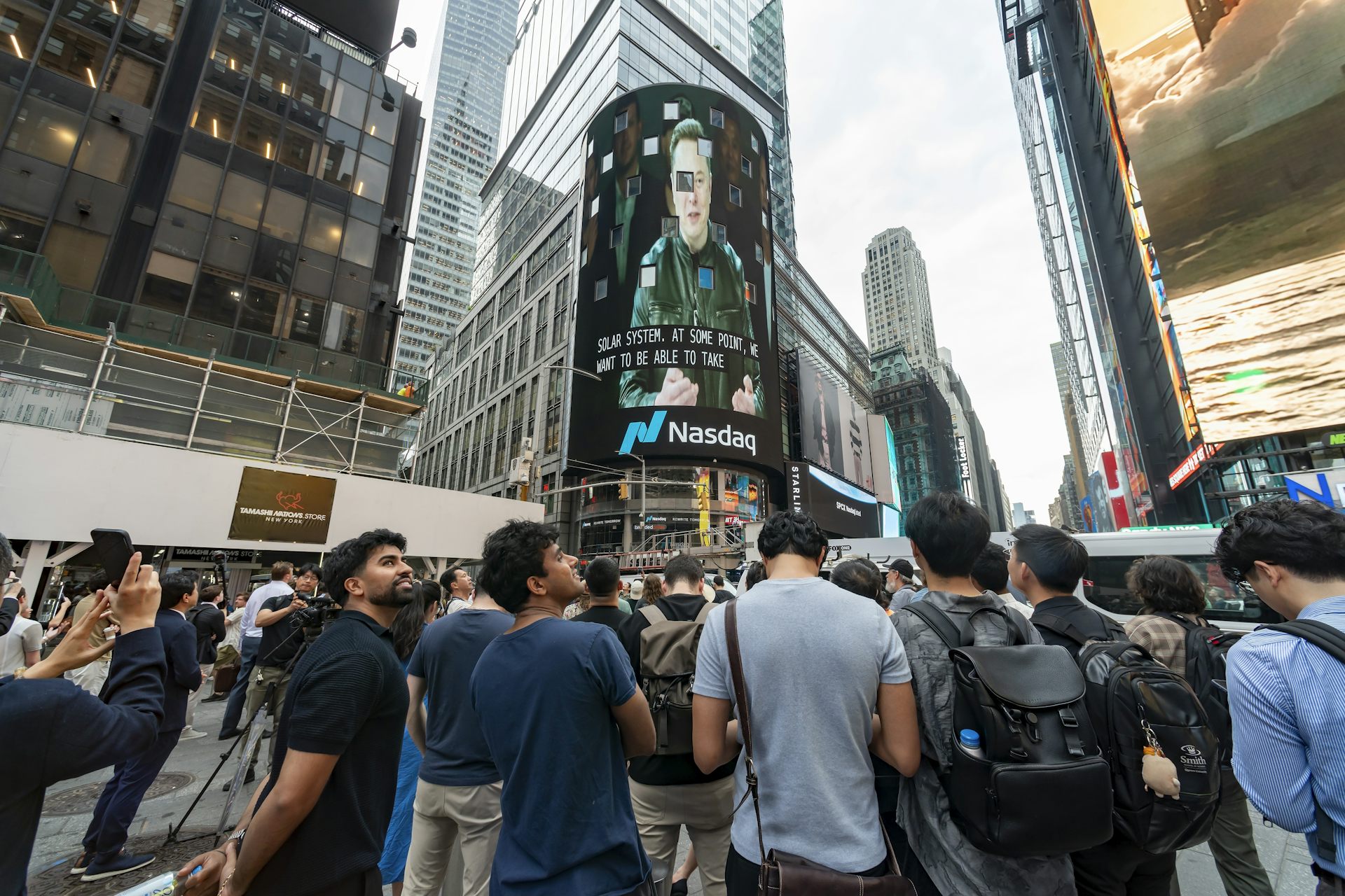 Personas concentradas frente a una pantalla en un edificio