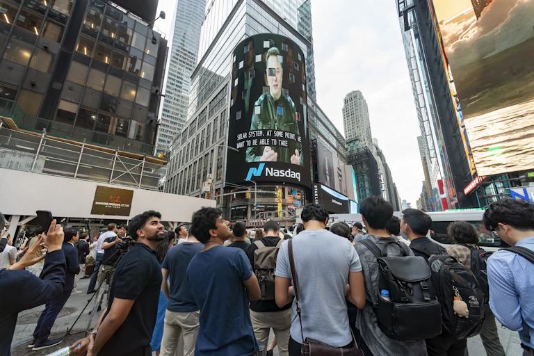 Personas concentradas frente a una pantalla en un edificio