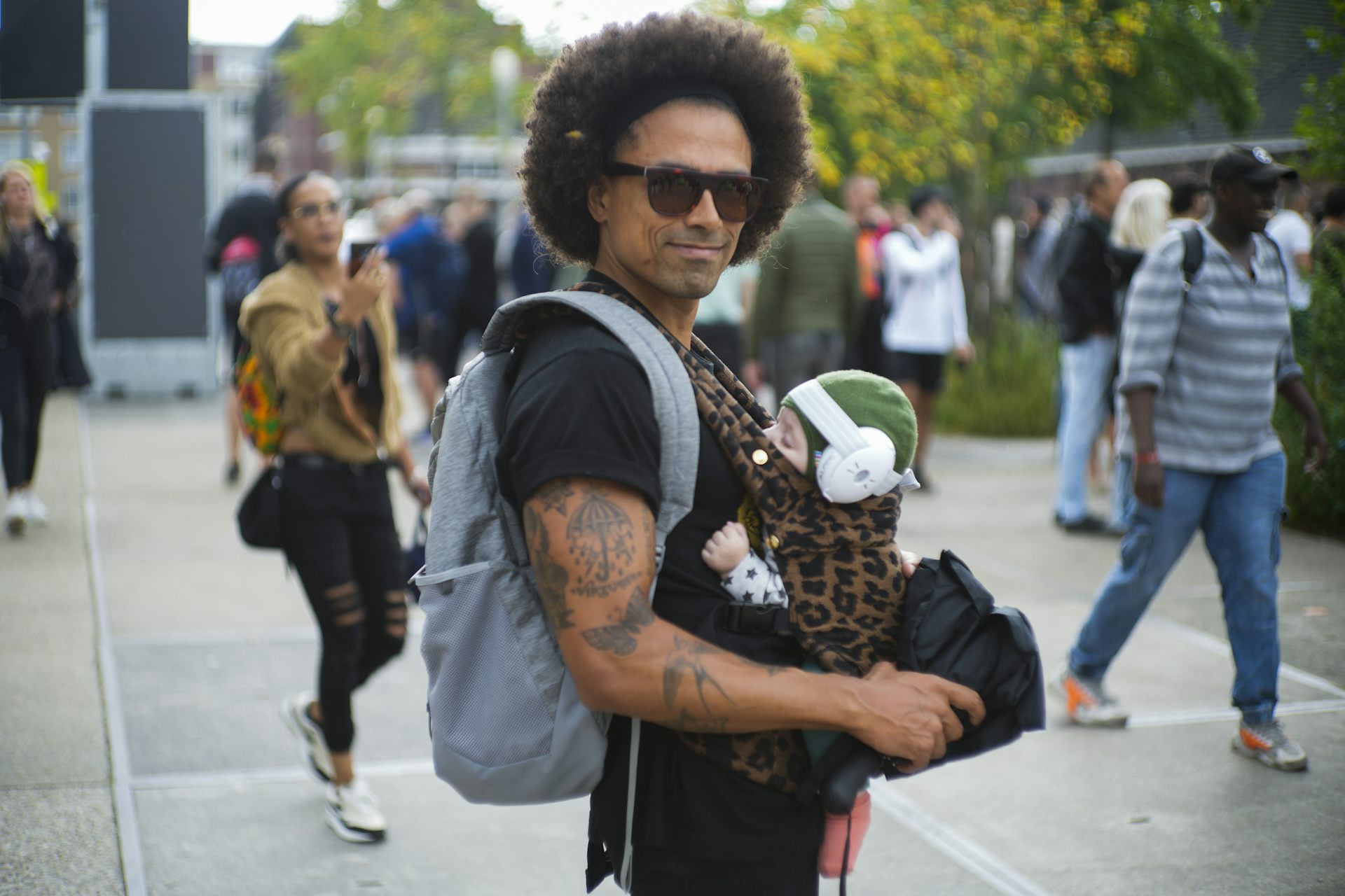 Un homme avec un bébé dans un porte-bébé sur le ventre.