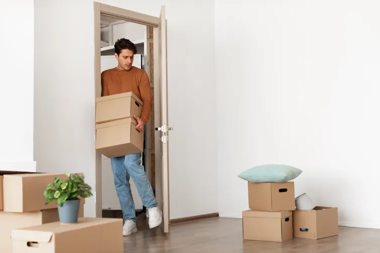 Man carrying boxes through a doorway.