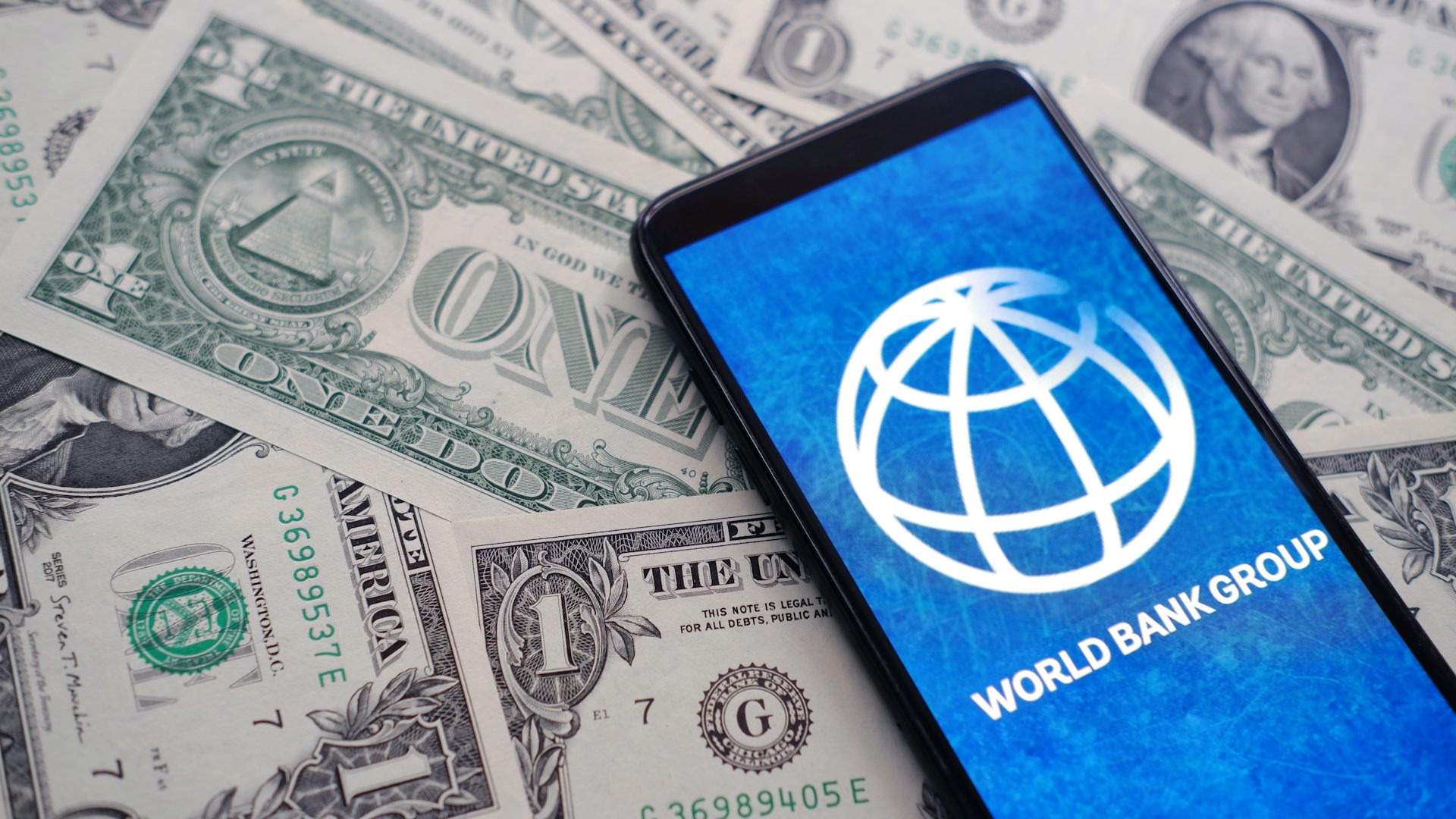 Logo de la Banque mondiale sur un tas de dollars.