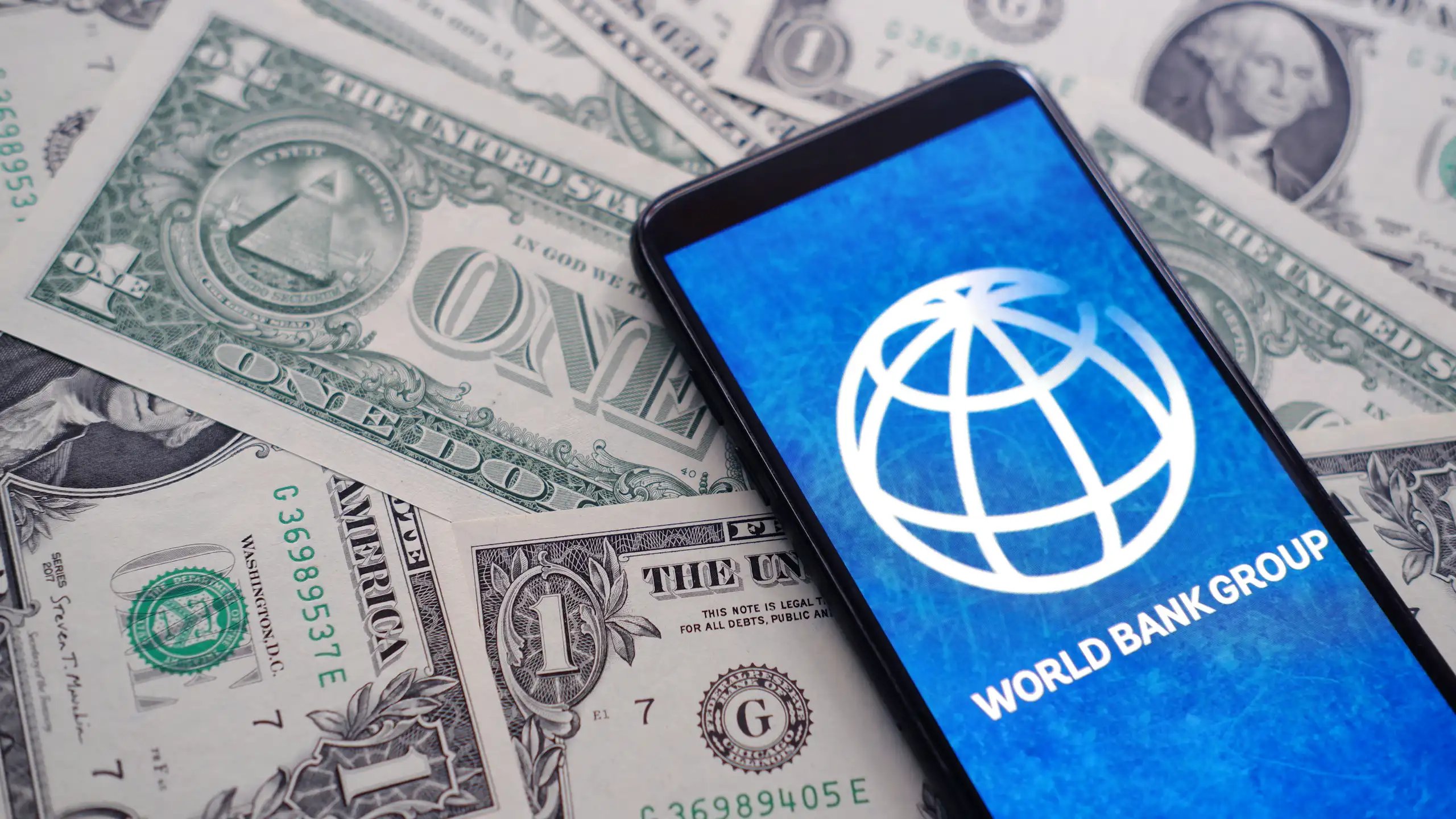 Logo de la Banque mondiale sur un tas de dollars.