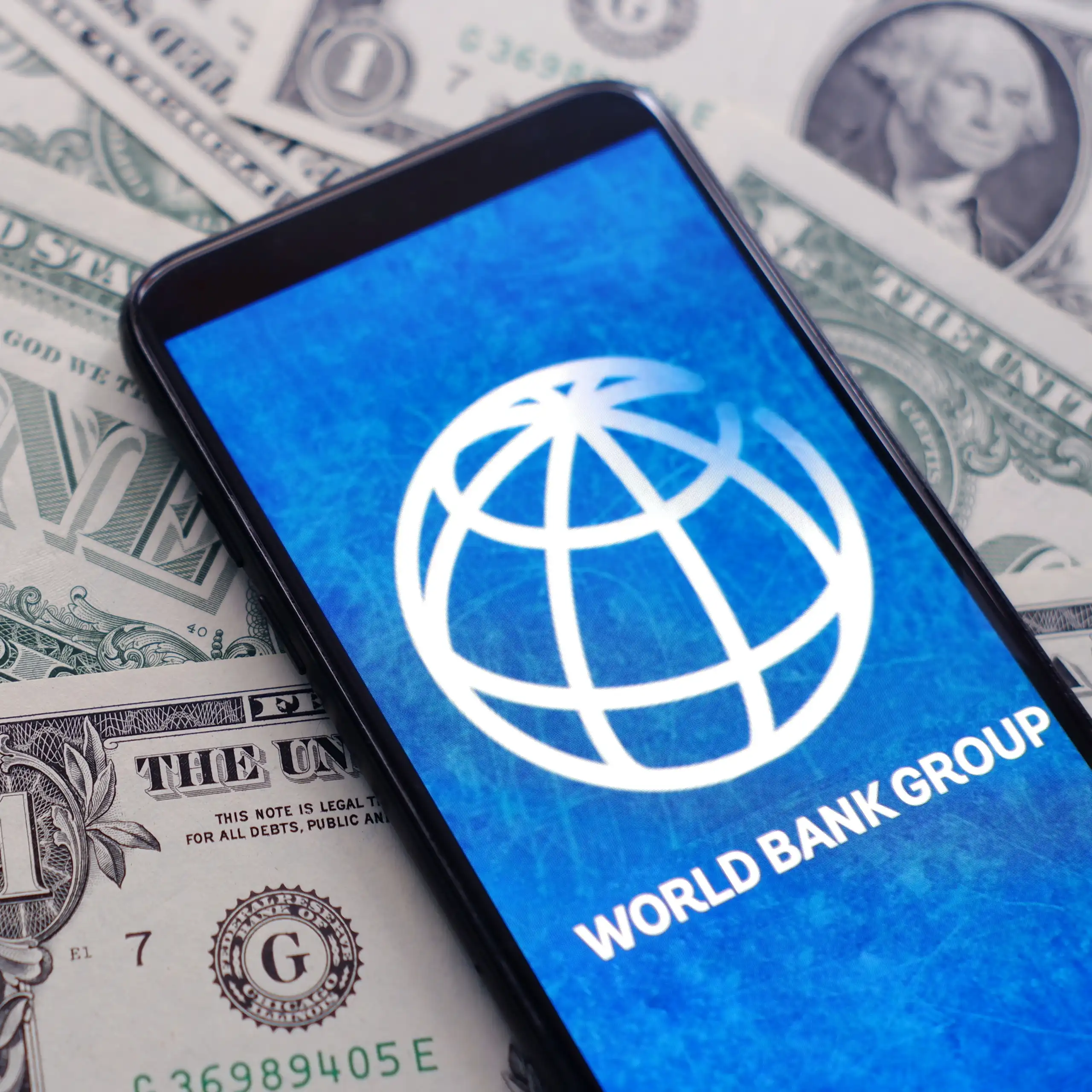 Logo de la Banque mondiale sur un tas de dollars.