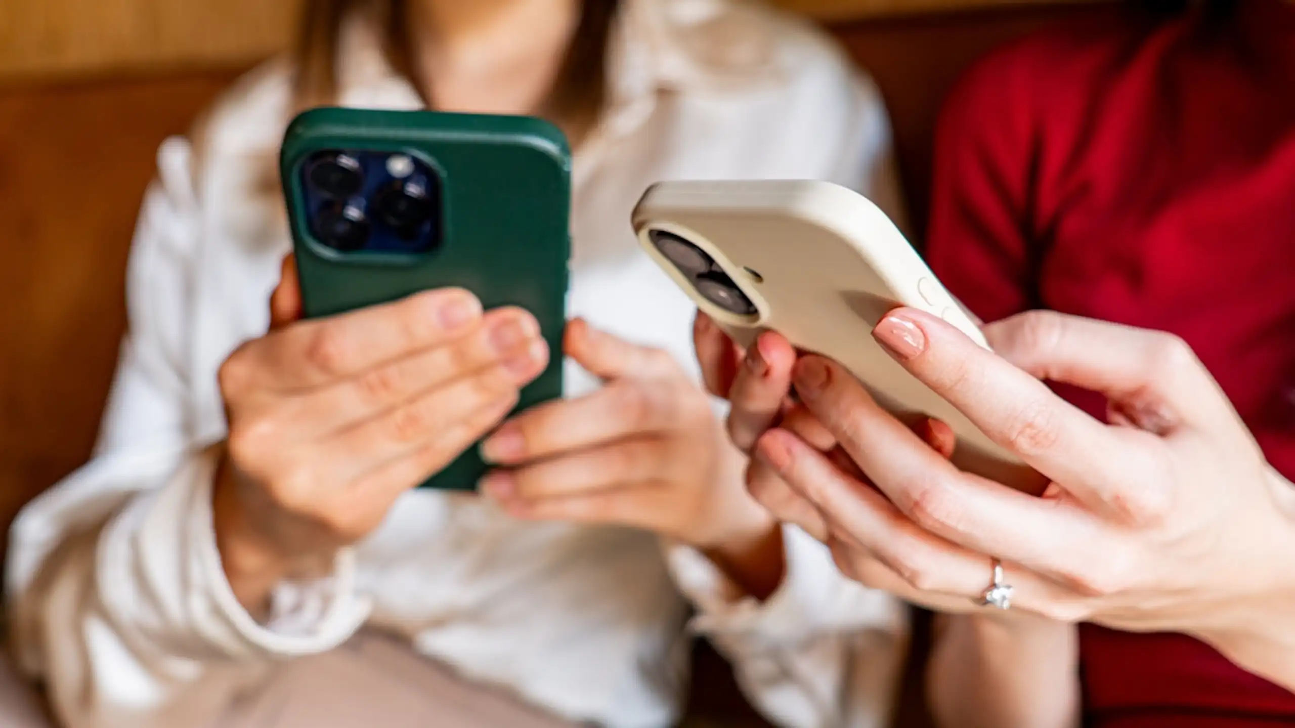 Deux personnes qui consultent des articles sur leurs téléphones.