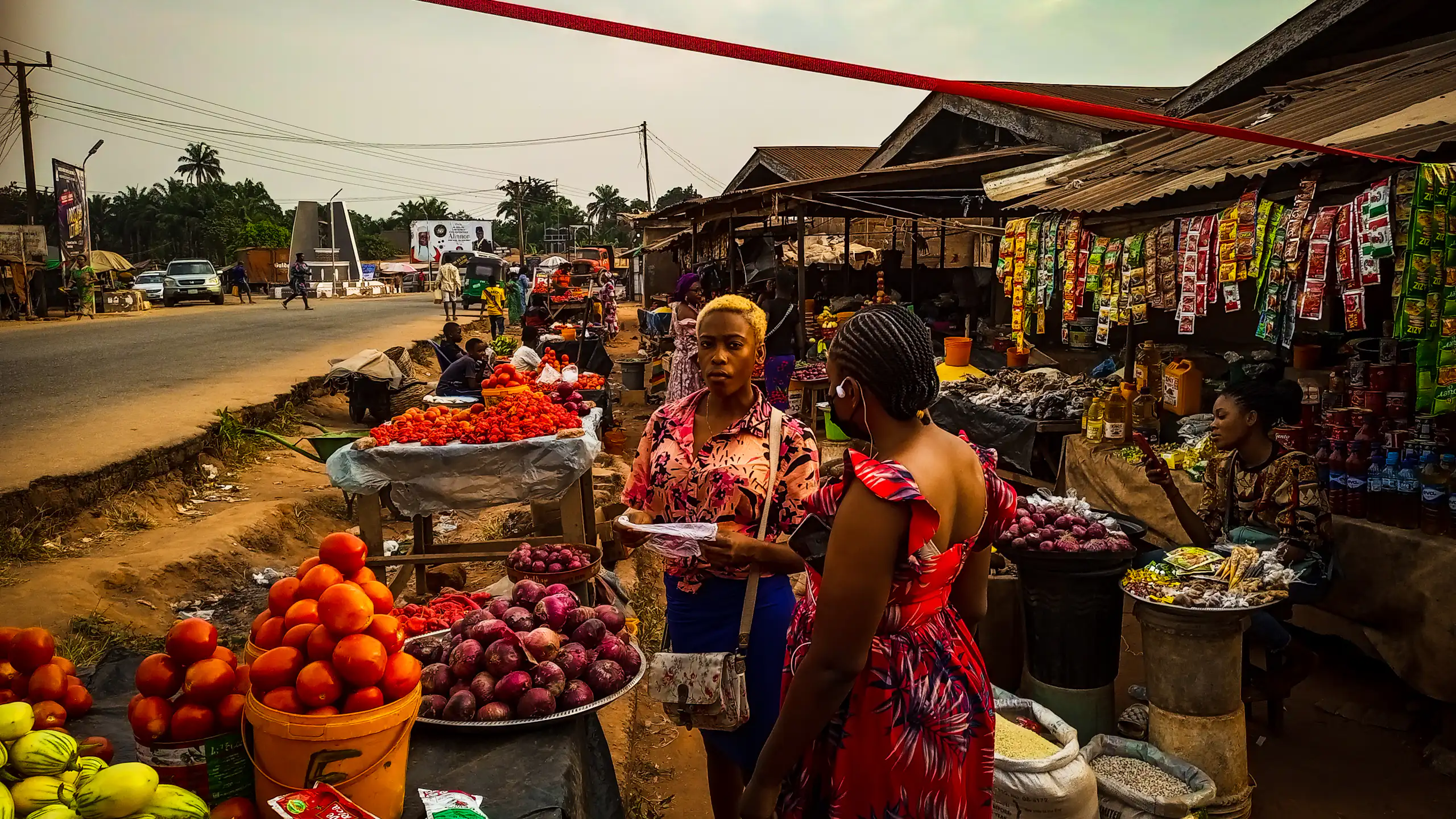 Women at a street market among displays of food items