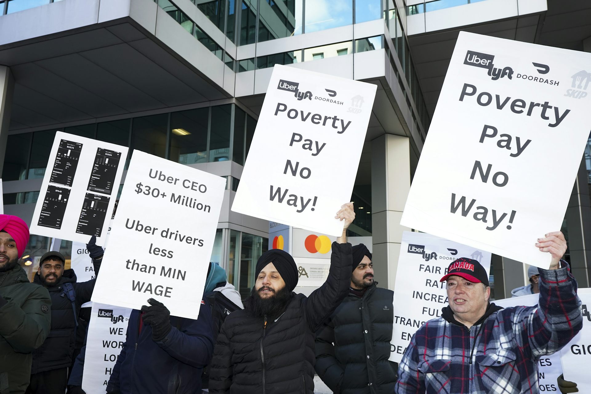 People holding protest signs asking for better pay and working conditions