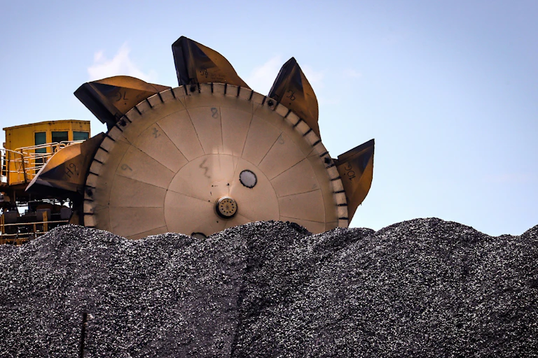 An excavator on a pile of coal at the Port of Newcastle.