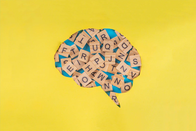 Dibujo de un cerebro con letras del Scrabble dentro