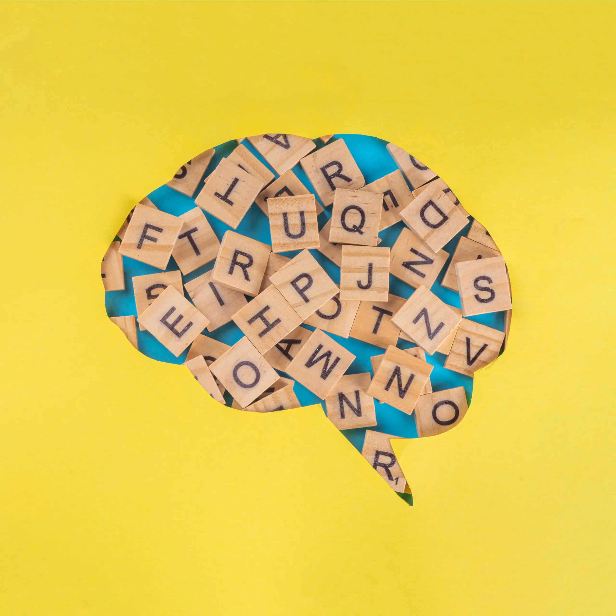 Dibujo de un cerebro con letras del Scrabble dentro