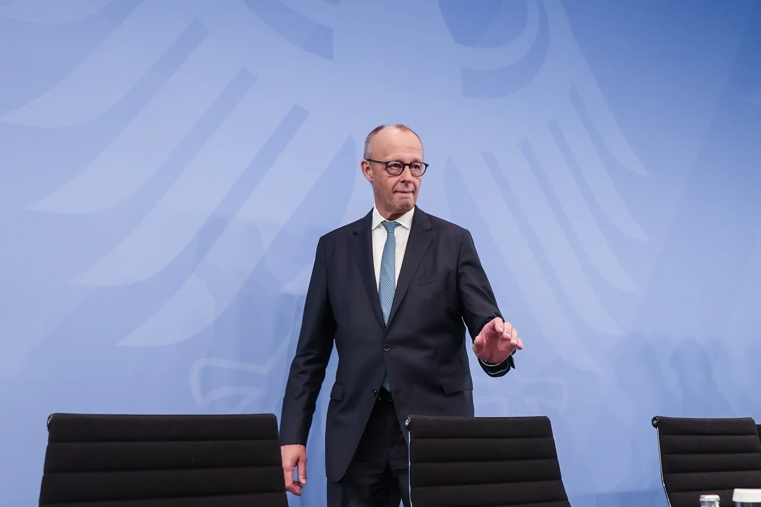 Friedrich Merz walks towards his seat ahead of a press conference.