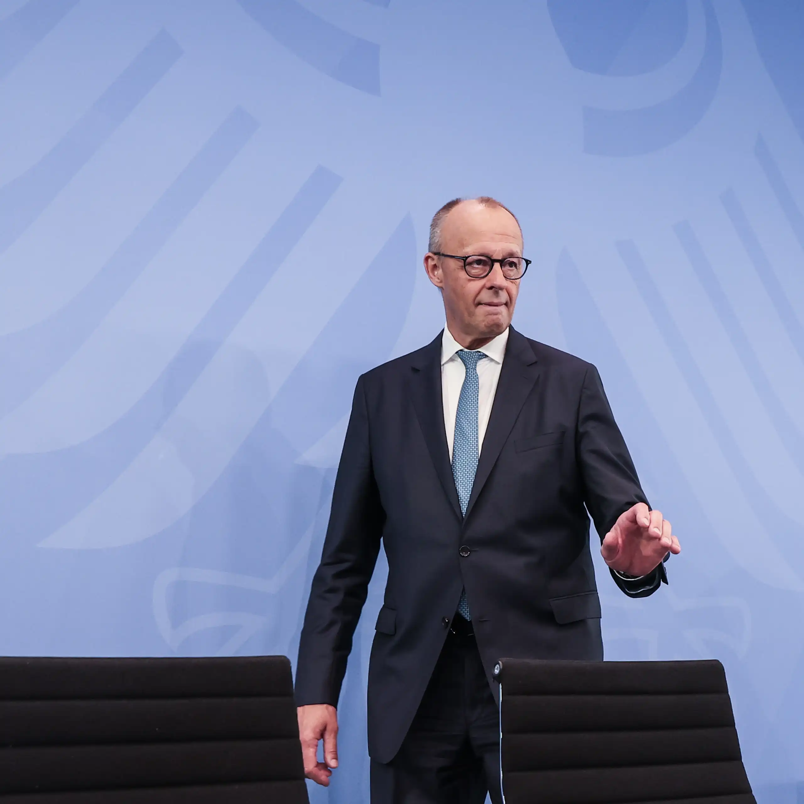 Friedrich Merz walks towards his seat ahead of a press conference.
