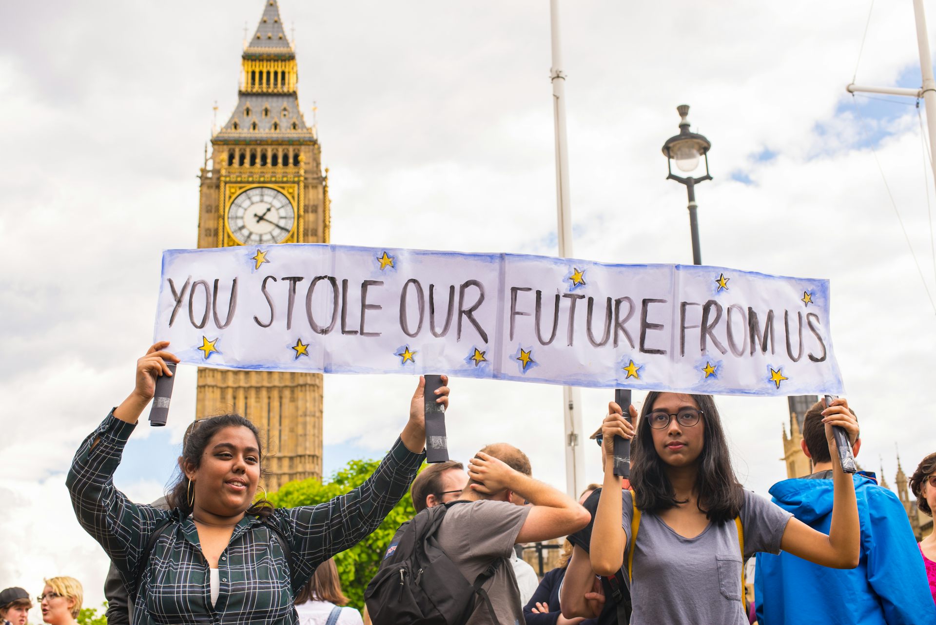 Young protestors holding a banner stating 'You stole our future from us'