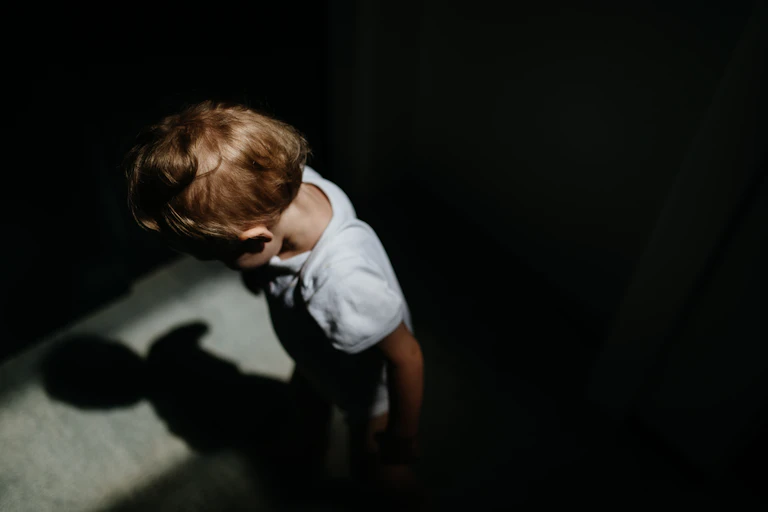 View from above of anonymous child in shadow