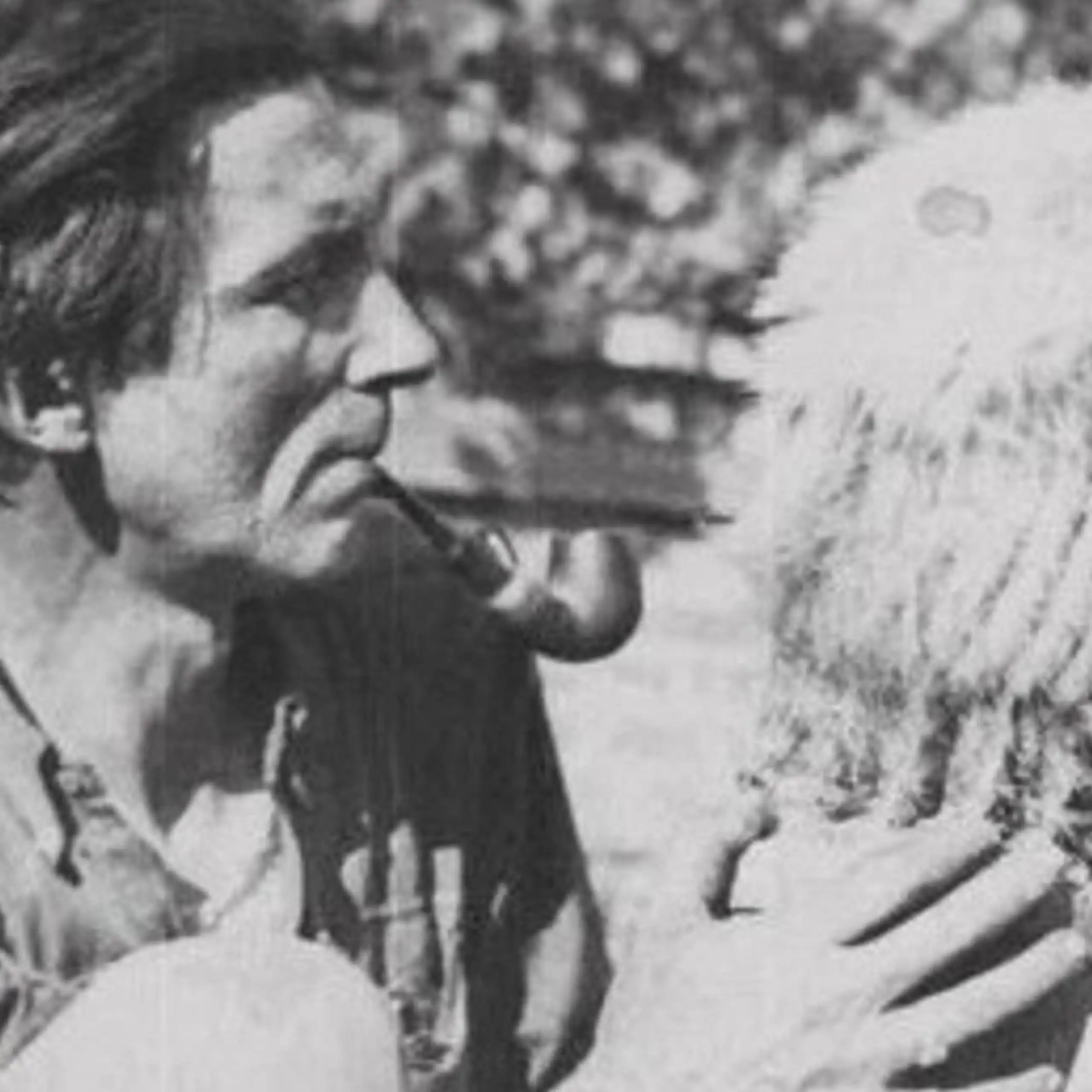 Man looks at cactus while puffing pipe