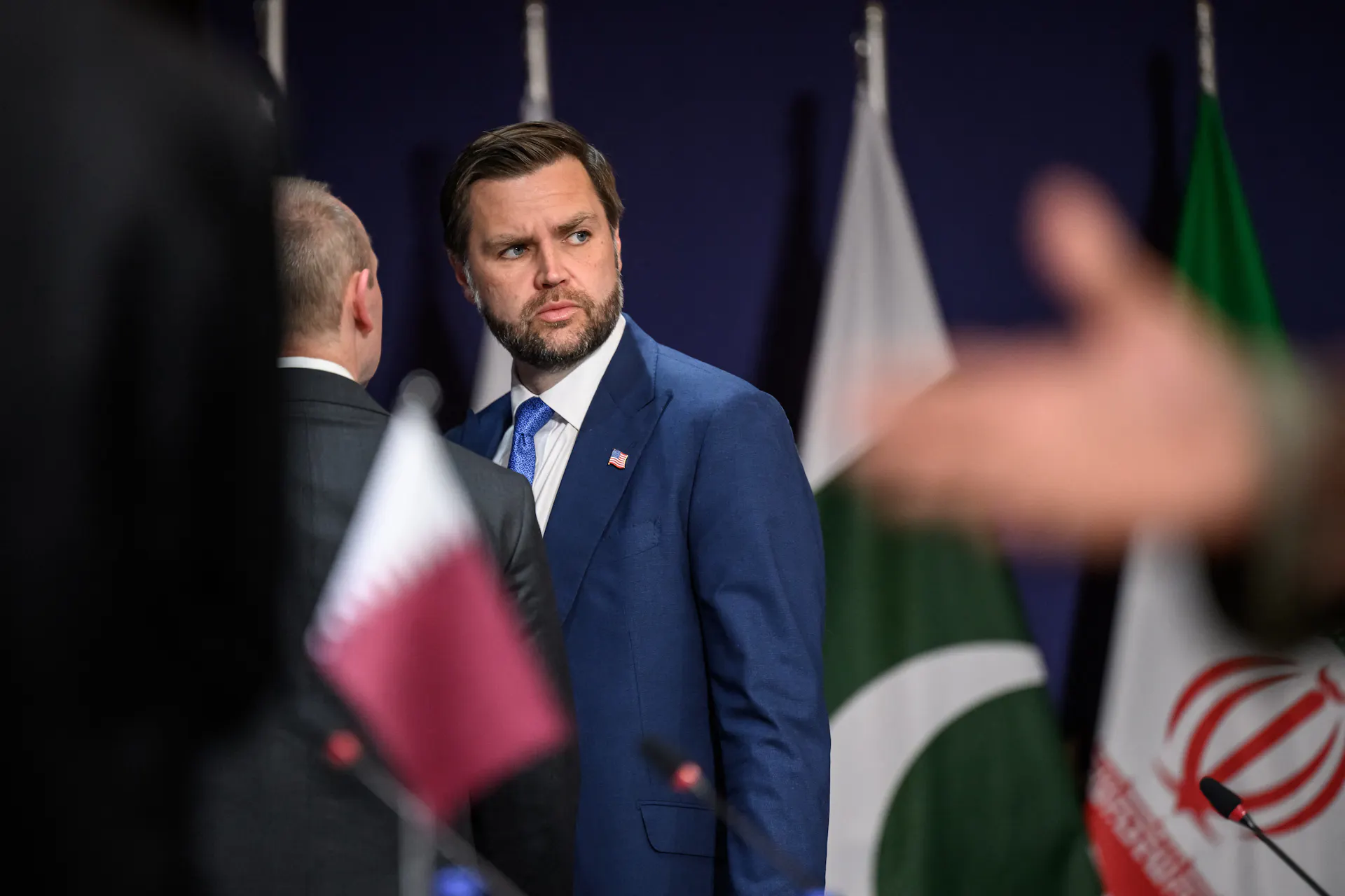 A man in suit and tie turns and looks backward.