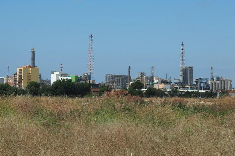 Vista desde un campo de chimeneas y edificios industriales al fondo