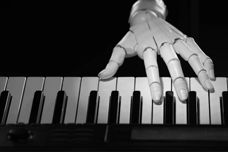 Robot hand playing synthesiser on black background.