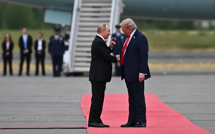 Vladmir Putin and Donald Trump shake hands on the runway at Alaska airport, August 2025.
