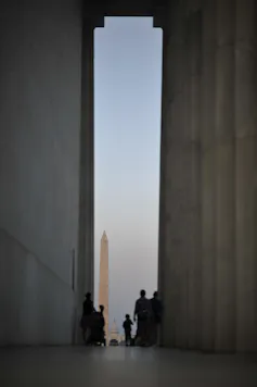 A sliver of a view from a tall open space to the Washington Monument's obelisk.