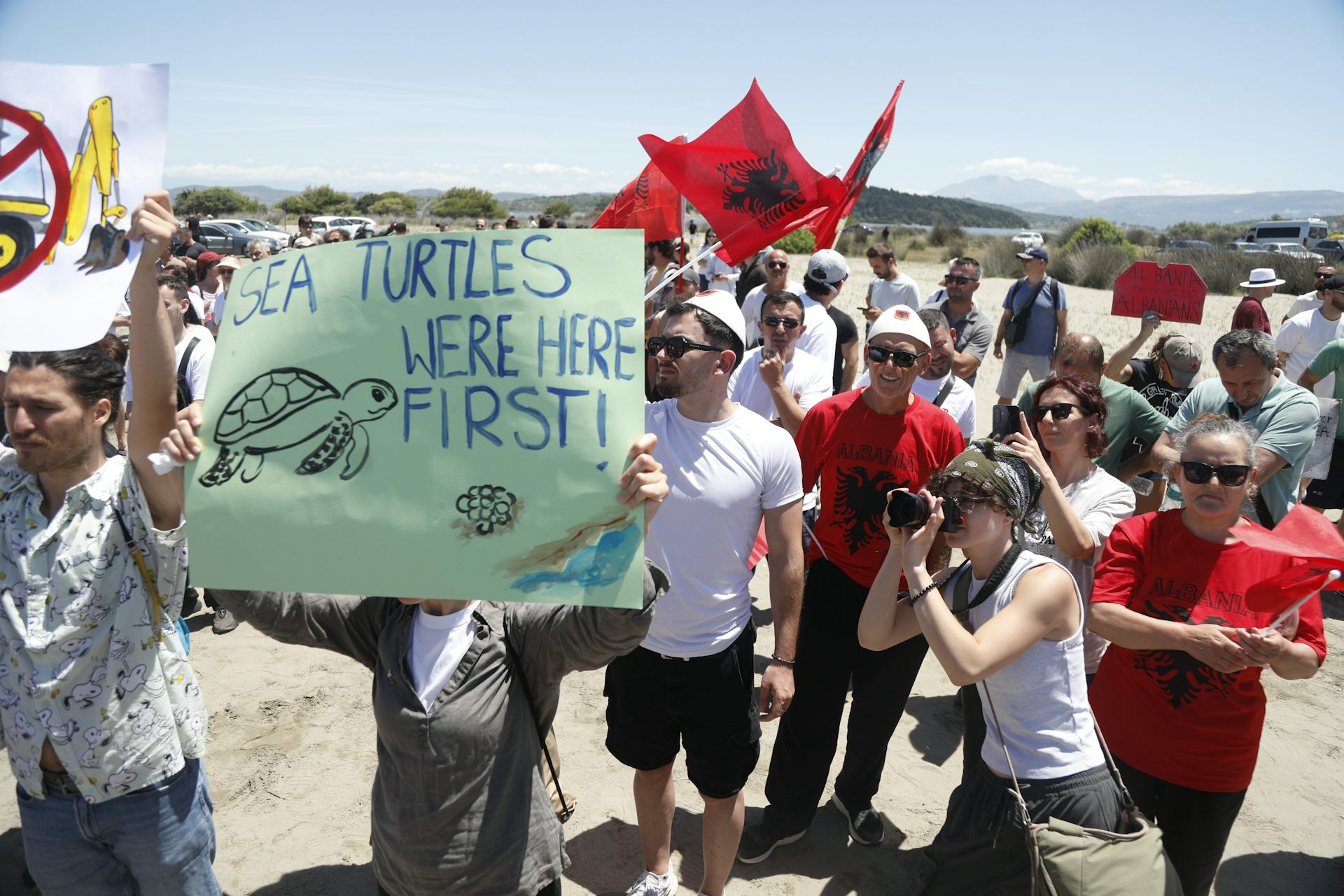 Protestors hold a banner reading 'sea turtles were here first!' in the area planned for a coastal resort project.