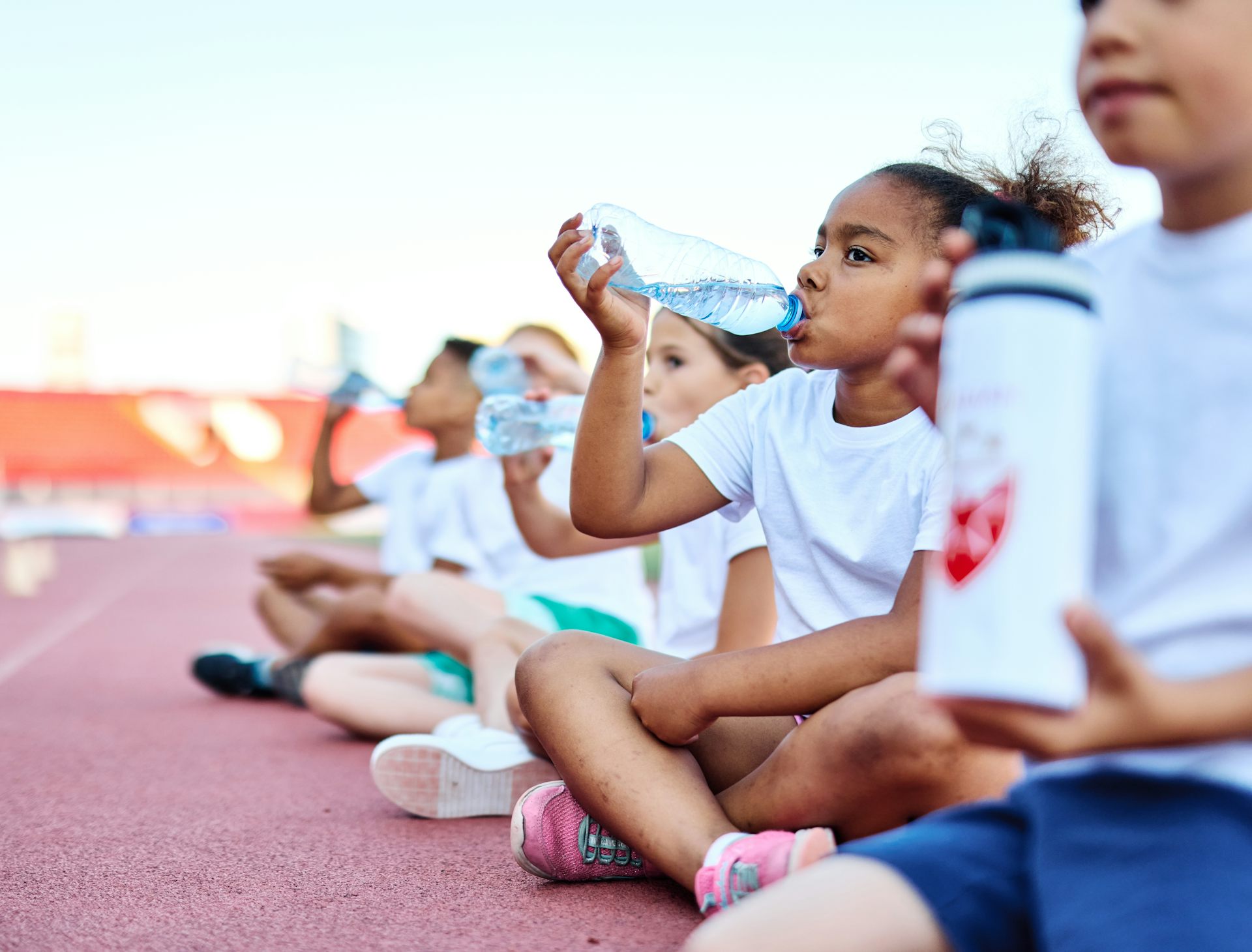 Children drinking at sports track