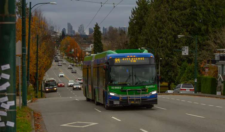 A long green bus on a road