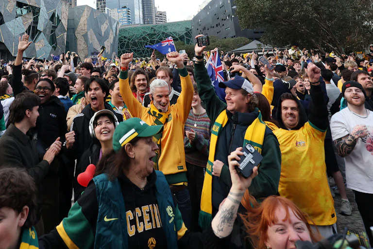 A crowd of cheering happy crowds in green and gold