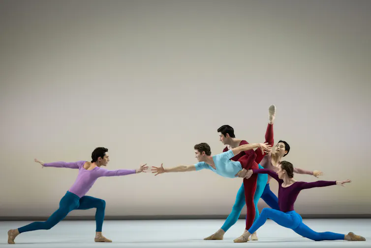 Five men: one reaches out a hand to the other four.