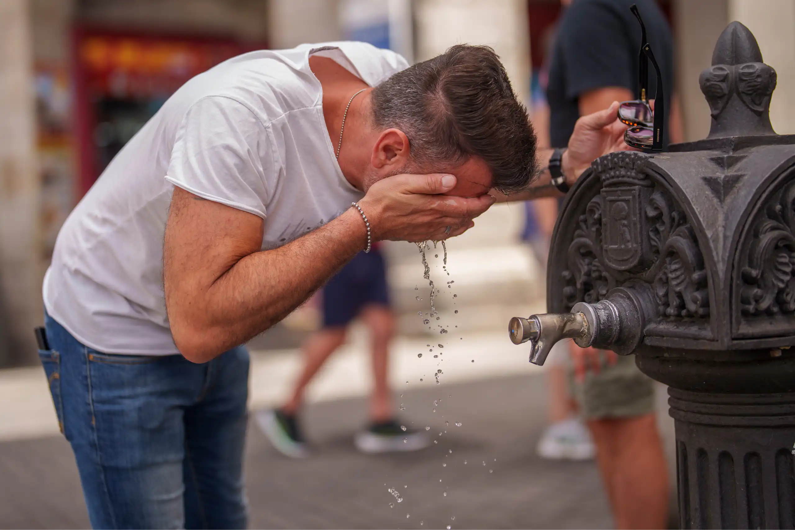 A man cools off in a fountain during a hot day in Madrid, Spain.