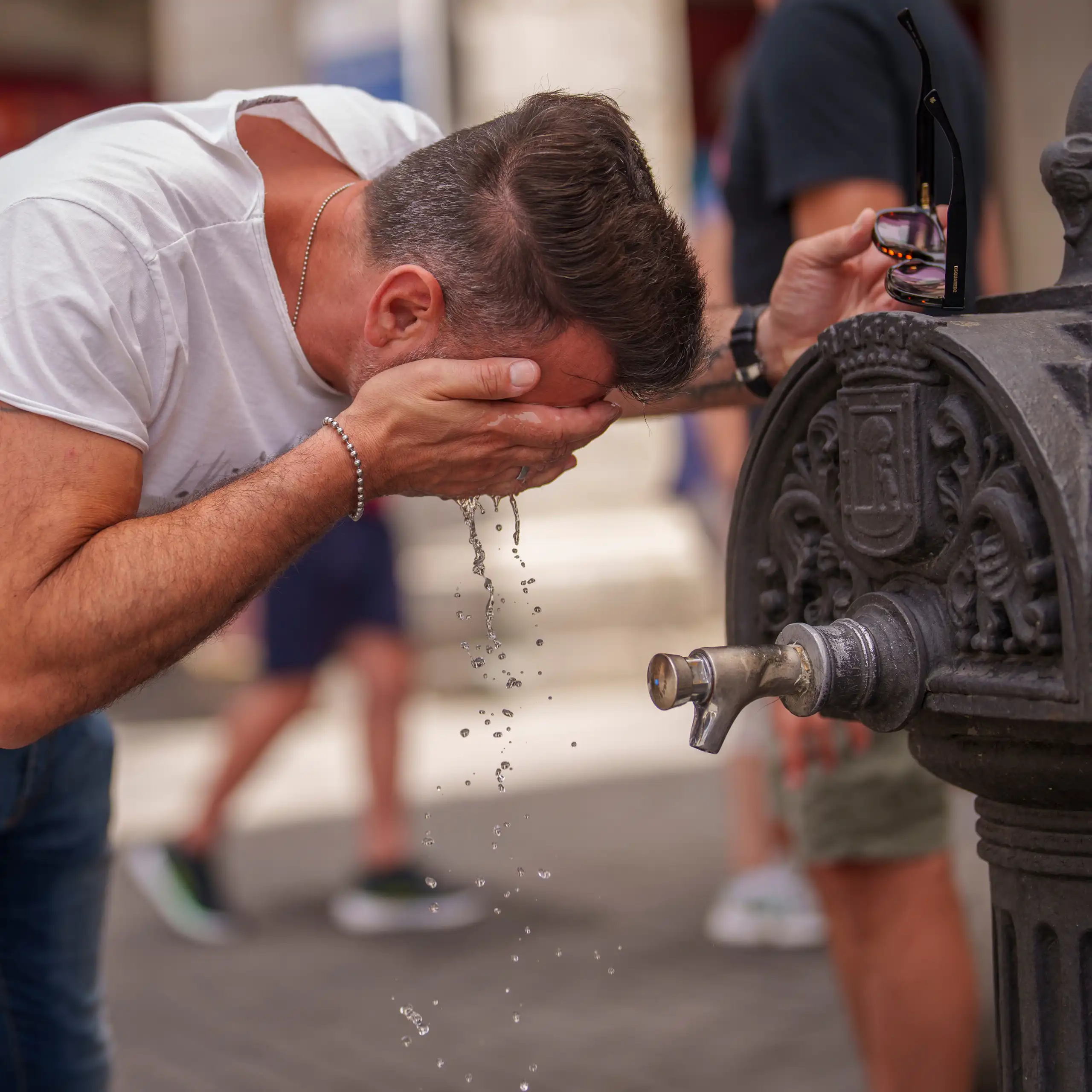 A man cools off in a fountain during a hot day in Madrid, Spain.