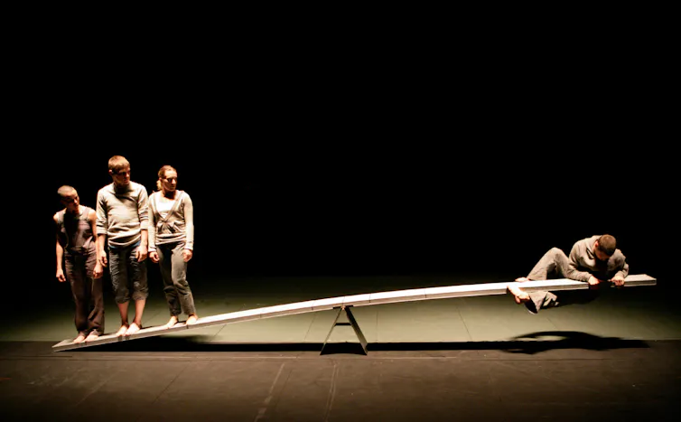Four dancers on a see-saw.