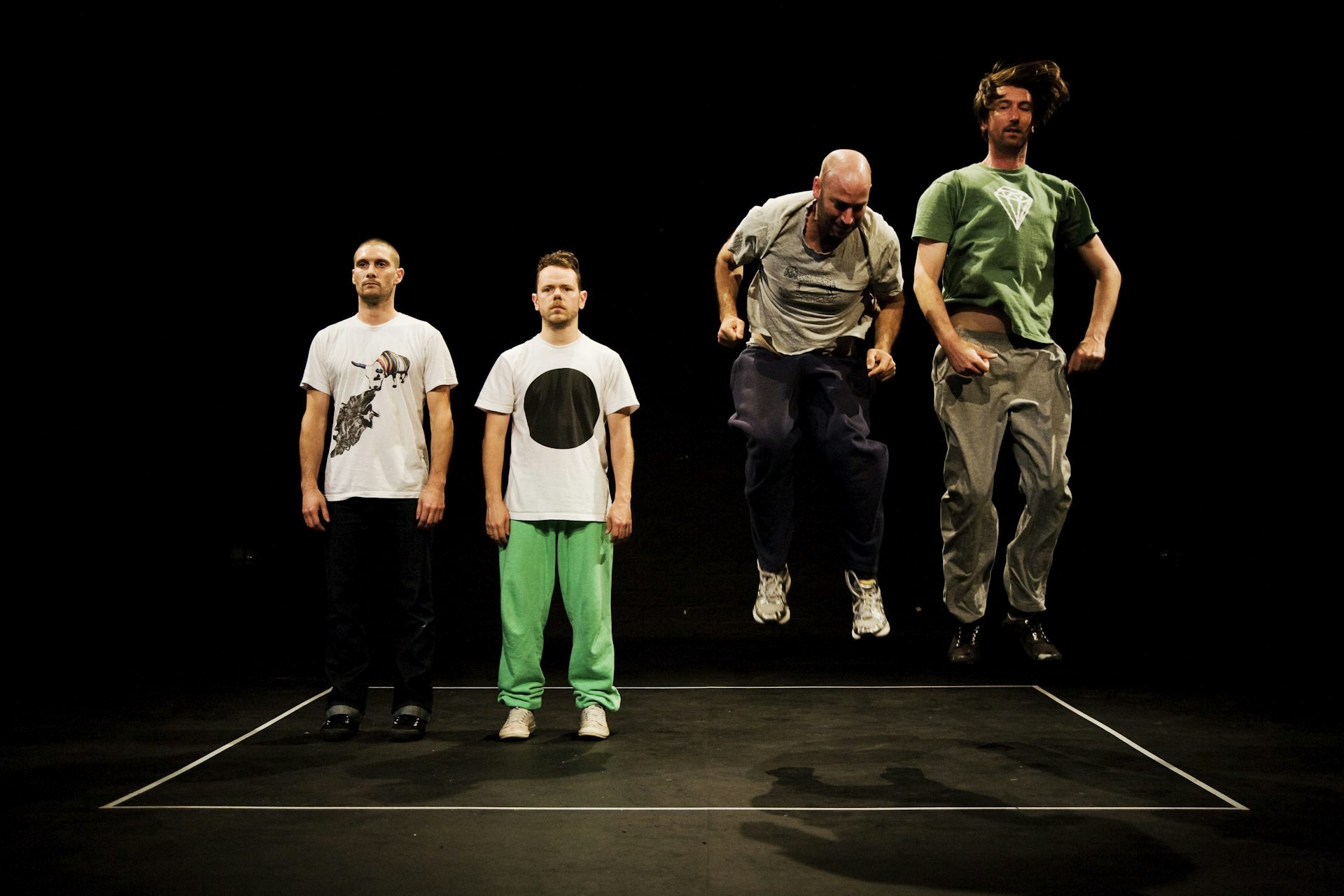 Two men stand; two men jump.