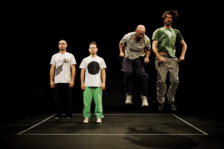 Two men stand; two men jump.