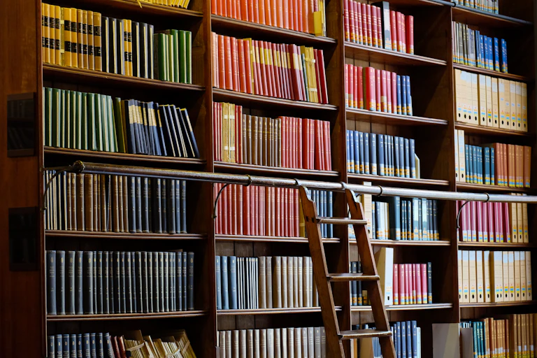 Pan de mur couverte d'étagères et de livres d'une bibliothèque universitaire.