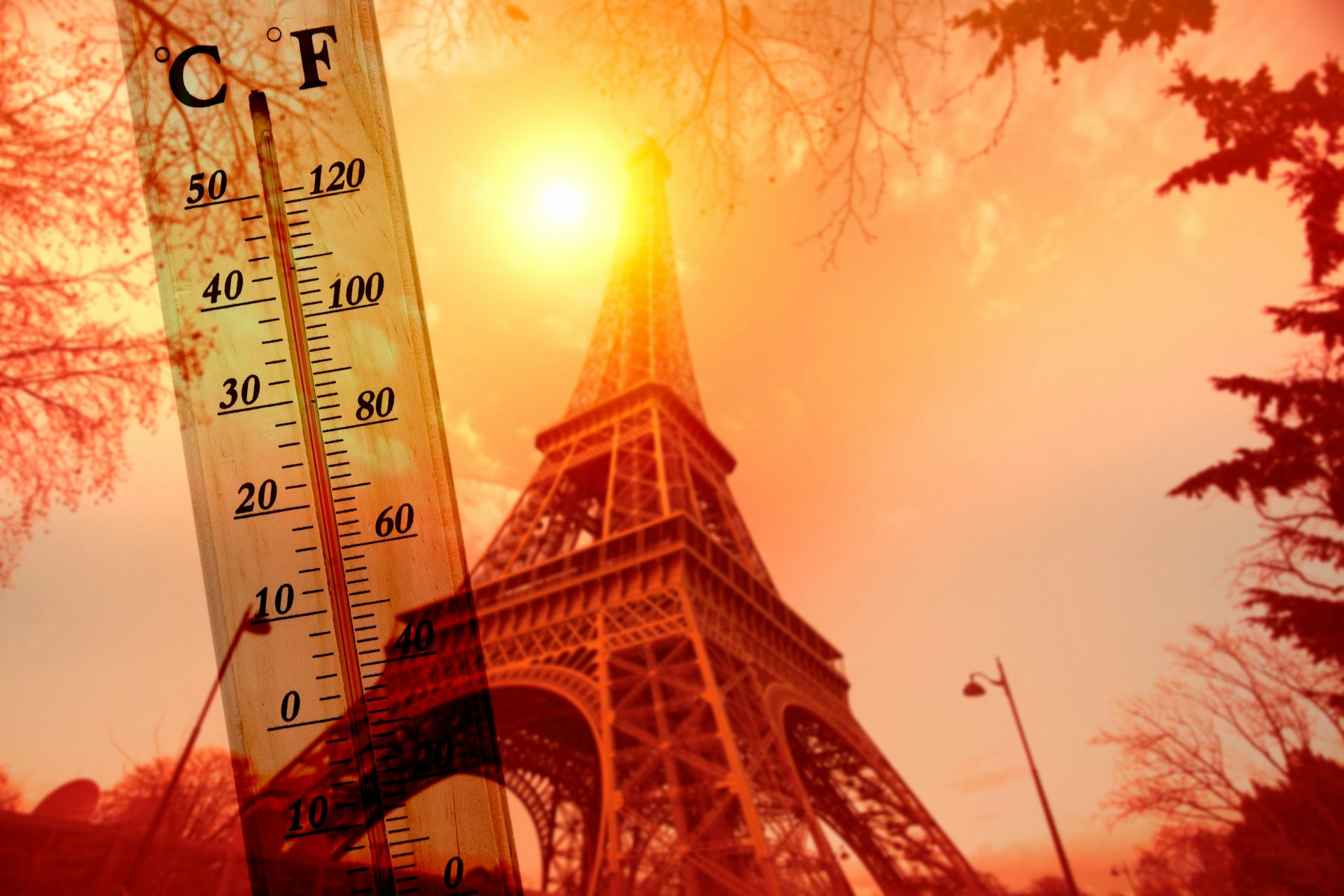 Une photo de la tour Eiffel baignée par le soleil brûlant, avec un thermomètre indiquant une température élevée.